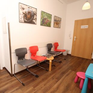 Room with pictures on the wall, chairs and a small table for toddlers